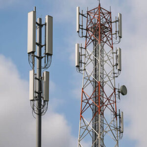 Monopole and traditional lattice telecom towers side by side, showing design differences for network infrastructure comparison.